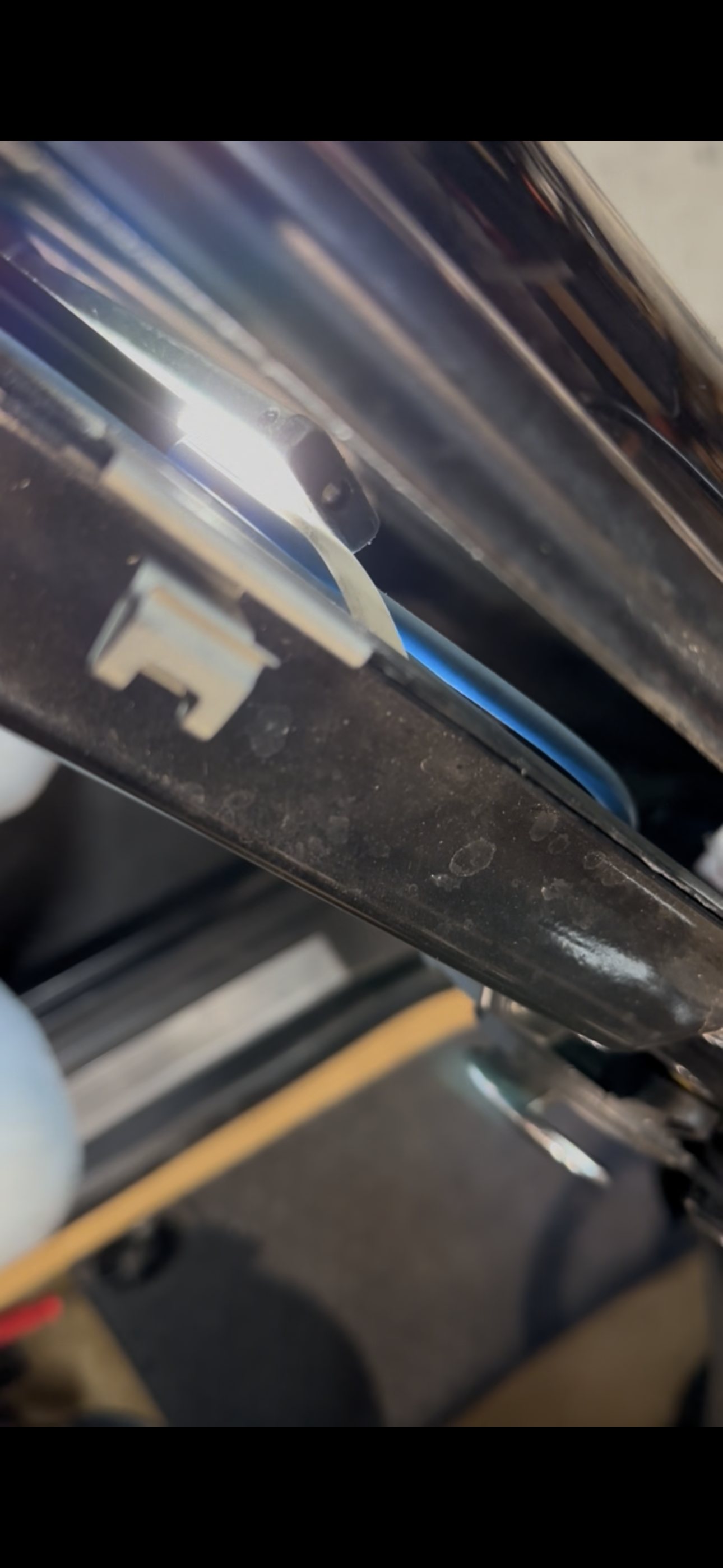 Blue window regulator cable routed beside the upper rear rail inside a MINI Cooper driver door