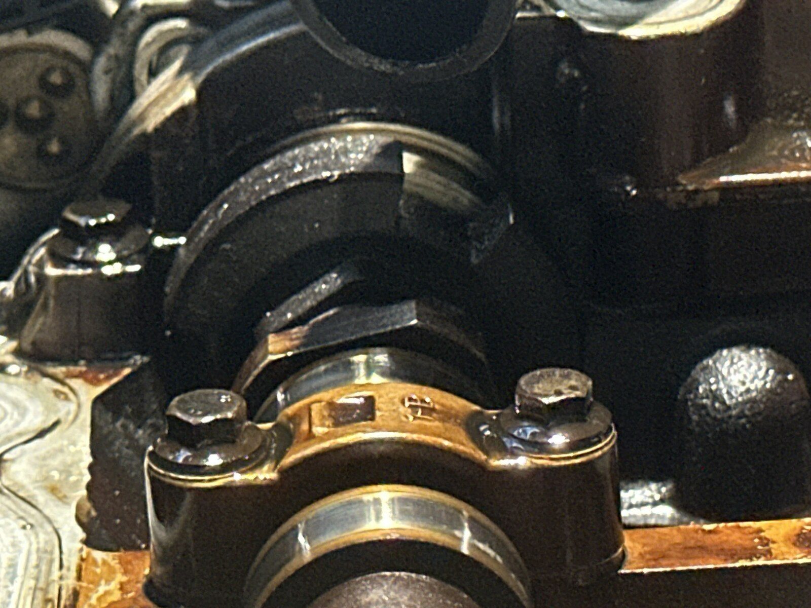 N14 cylinder head with a camshaft bearing cap in the foreground and the machined camshaft timing flats behind it sitting at an angle rather than horizontal