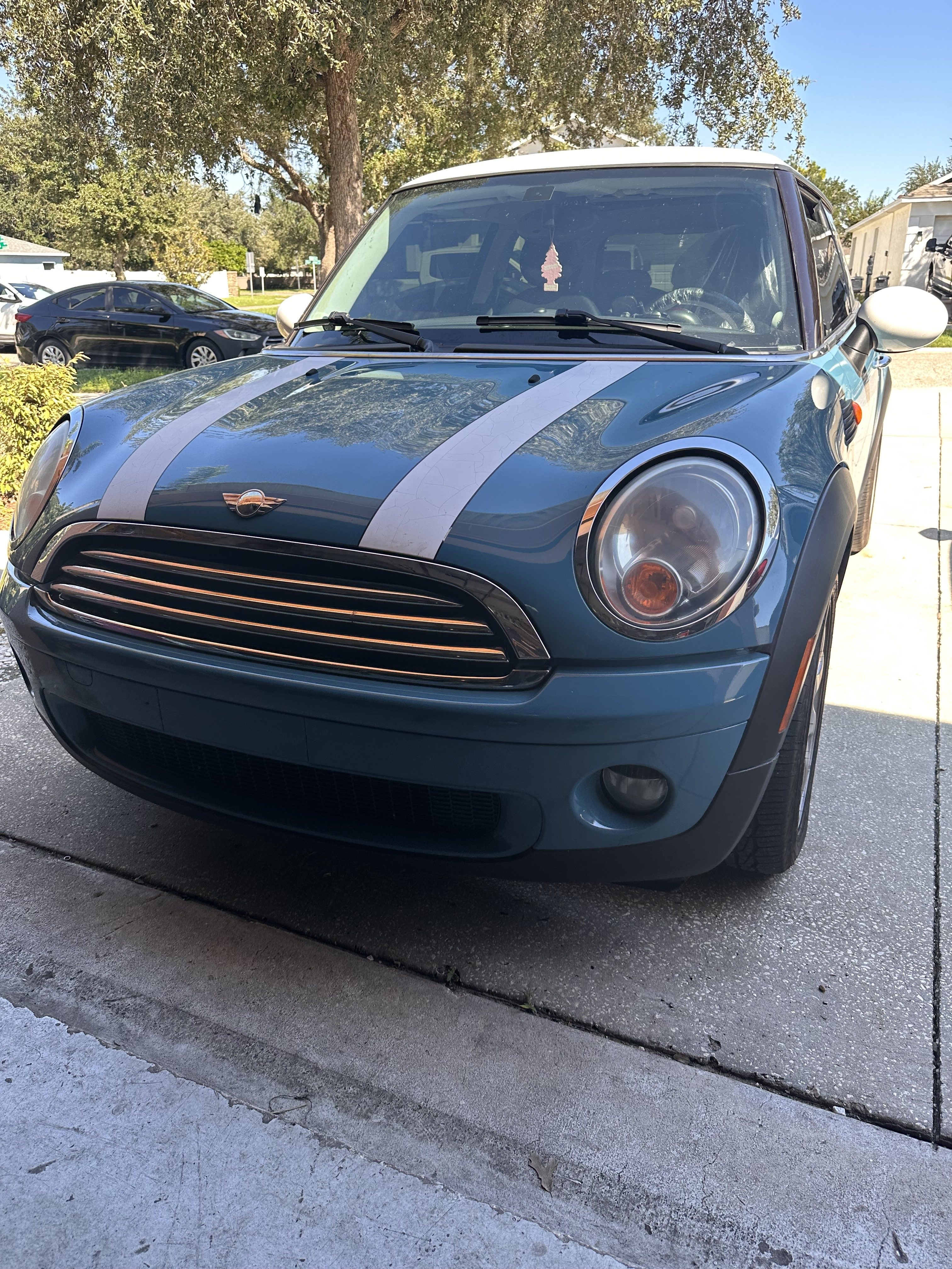 Front of a blue 2010 MINI Clubman with white bonnet stripes, parked on a driveway