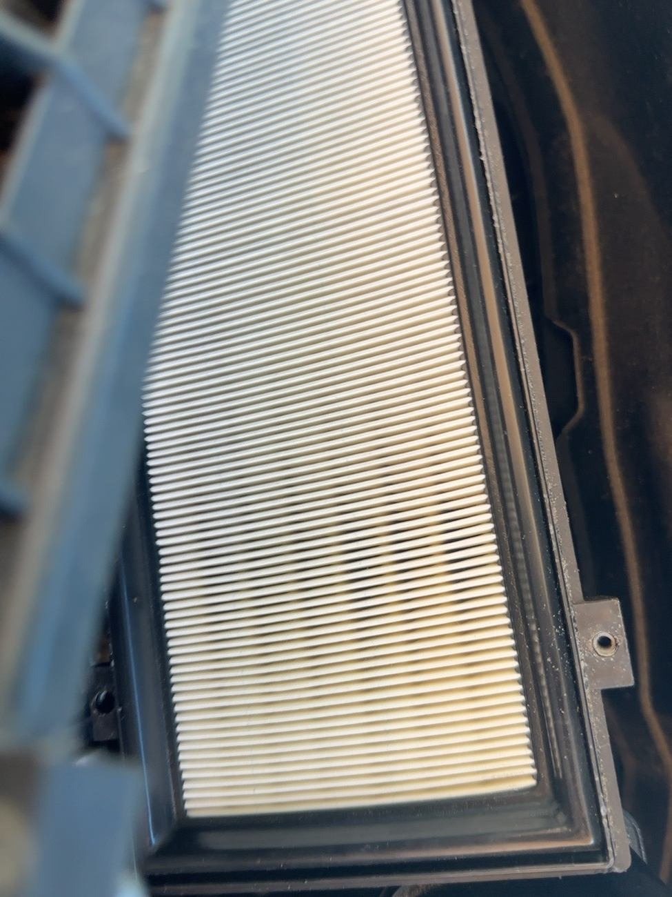 Engine air filter element in its housing with clean, light-coloured pleats