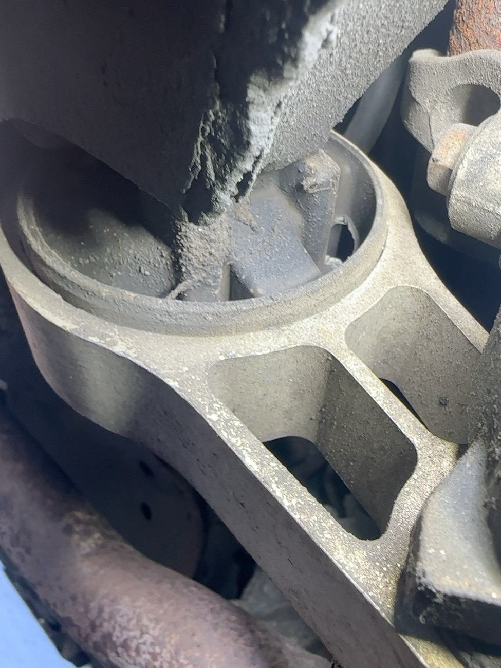 Lower engine torque mount and its rubber bushing seen from under the car