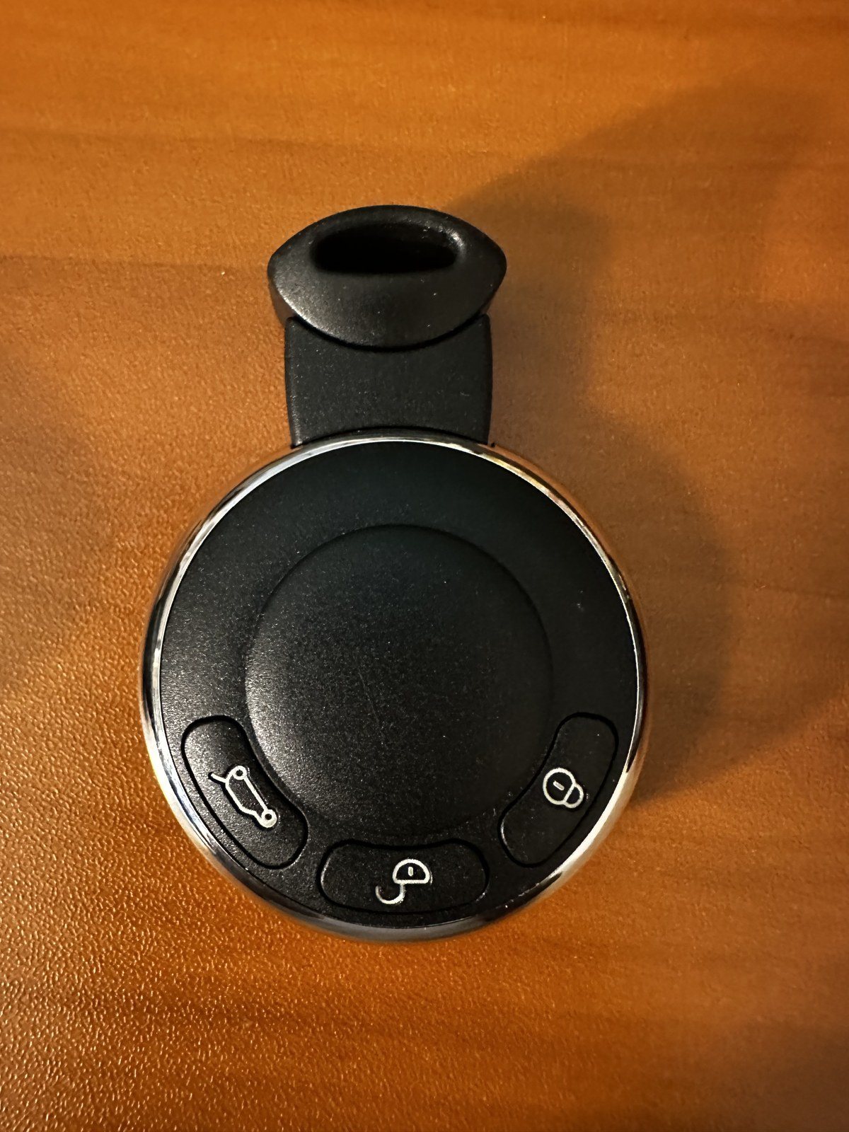 Round black second-generation MINI key fob with lock, unlock and boot release buttons around its outer edge