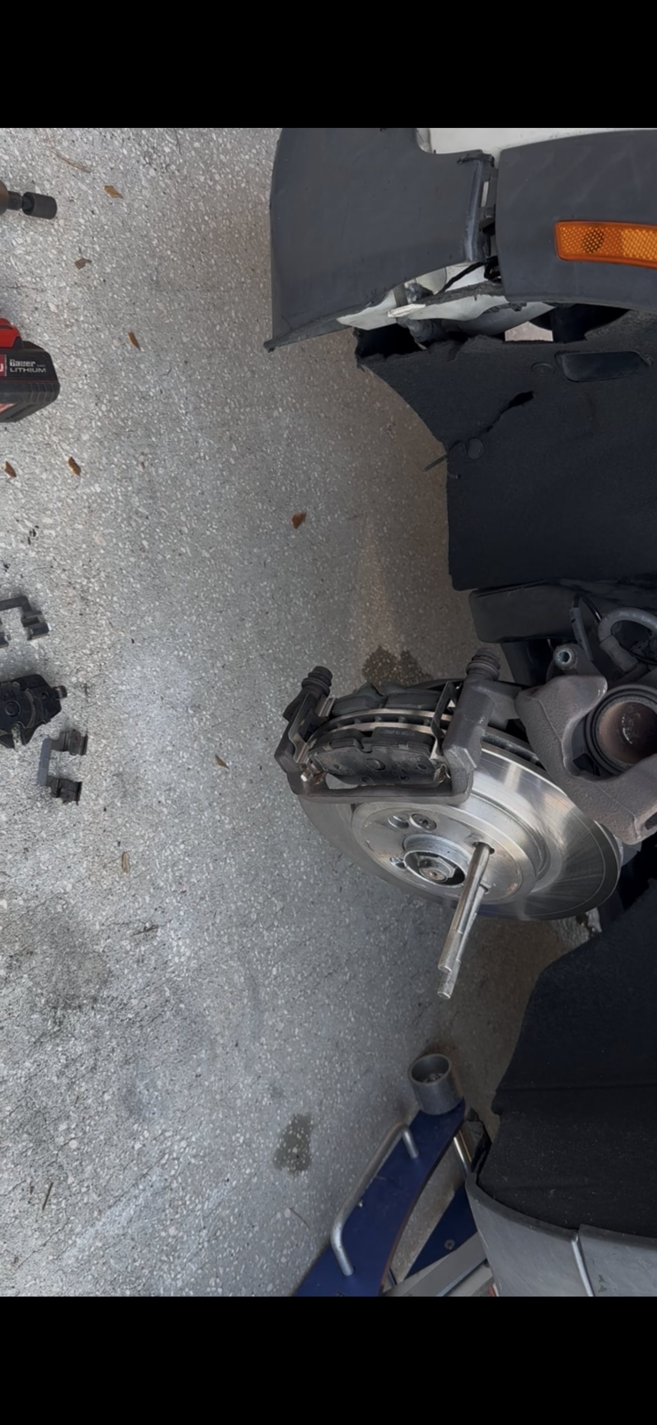 Front wheel removed from a MINI Cooper Coupe S showing the caliper, new rotor and suspension area during brake service