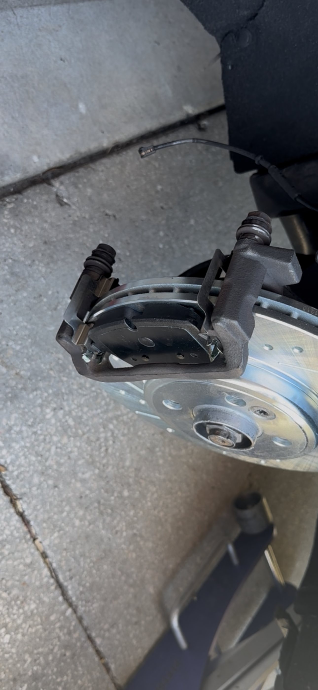Installed front brake caliper and drilled and slotted rotor after pad and rotor replacement