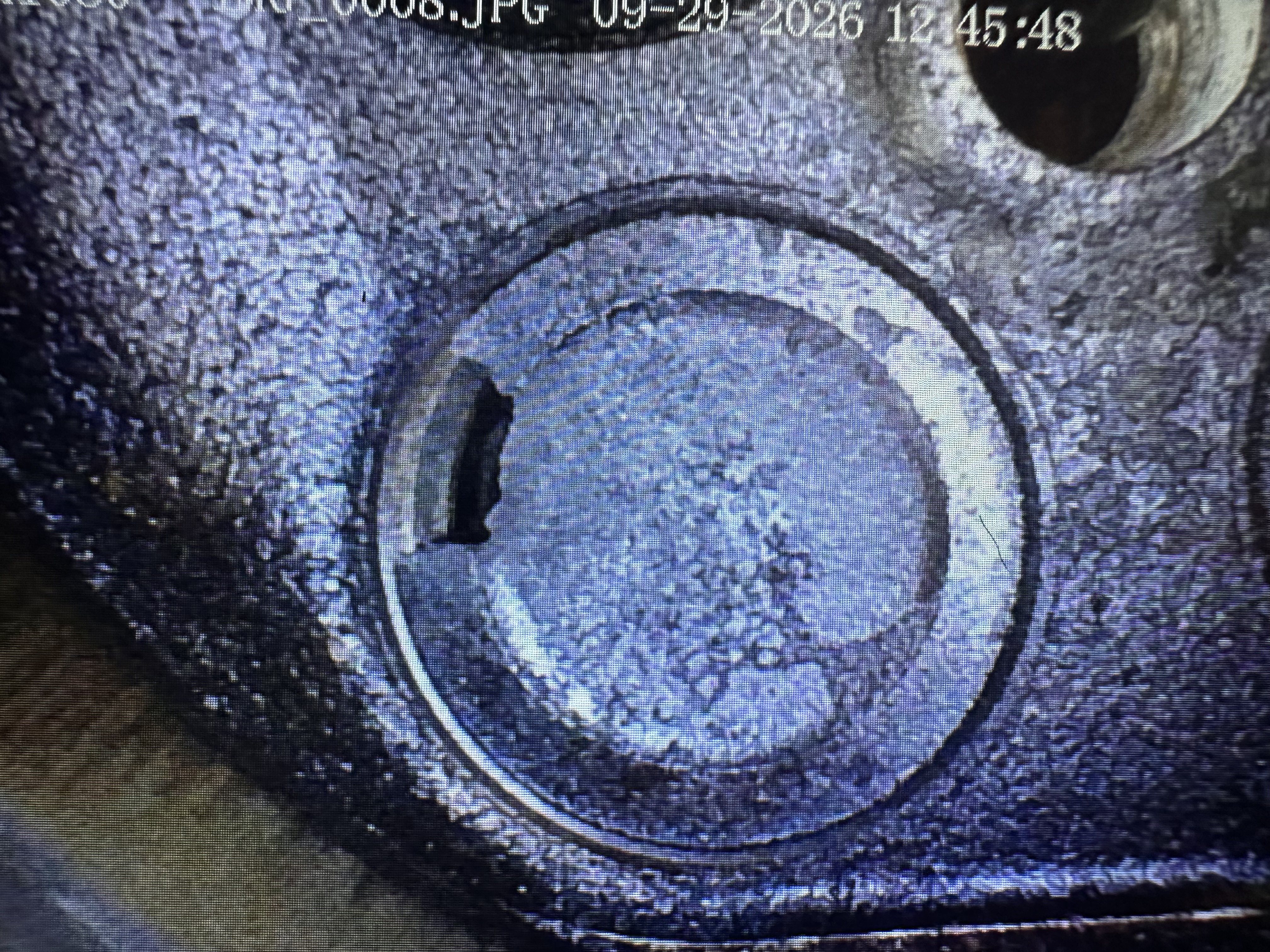 The same cylinder 1 exhaust valve seen from a second borescope angle, with the notch at the left edge of the valve head.