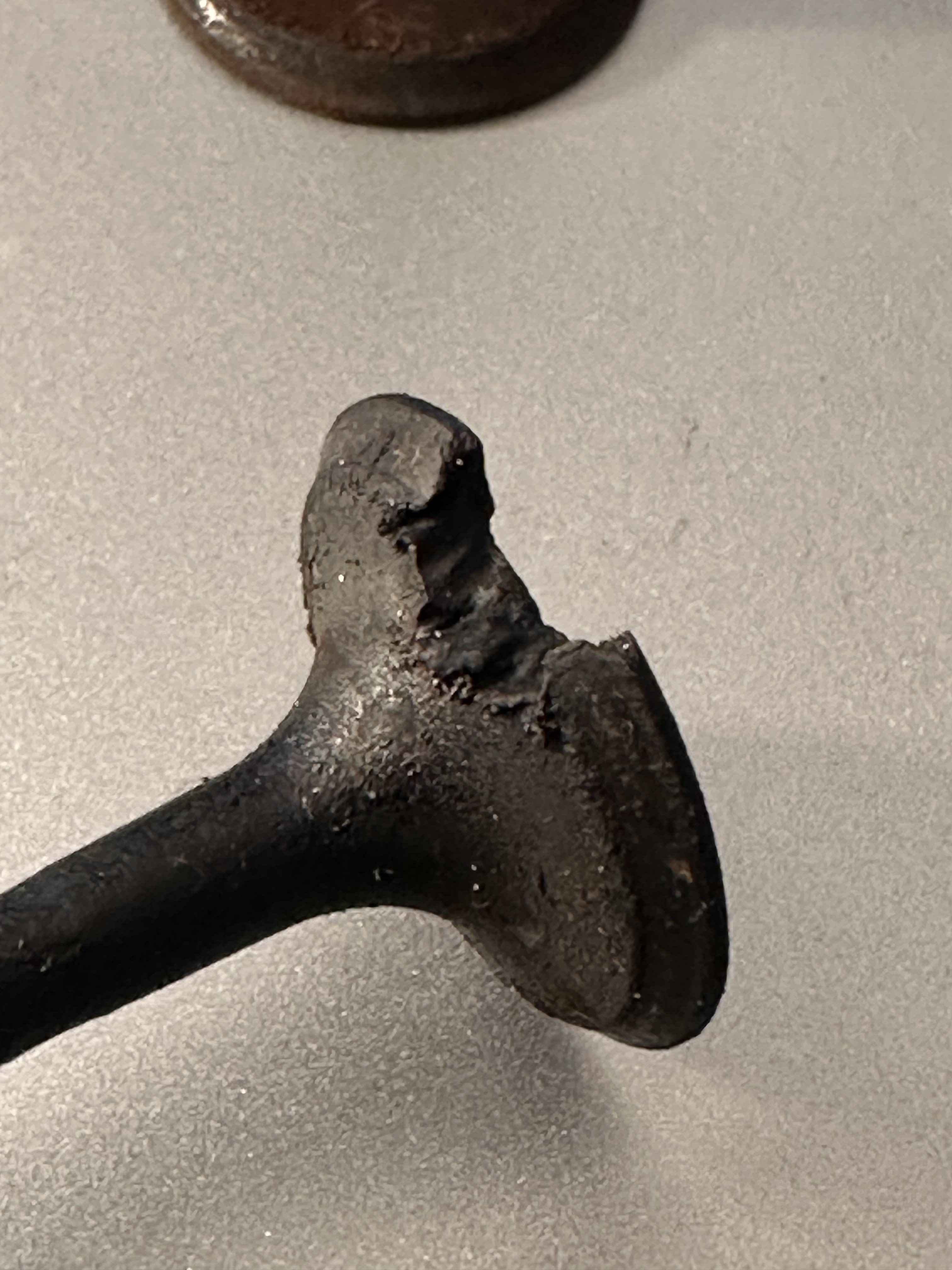 Removed exhaust valve with a section burned out of the edge of the valve head