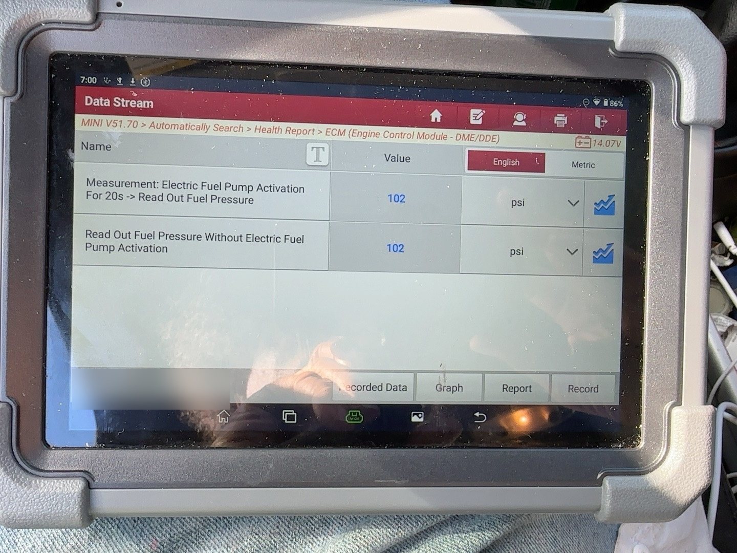 Scan tool live data screen showing low-pressure fuel system pressure of 102 psi with the trace holding steady. Vehicle identification in the footer is blurred.