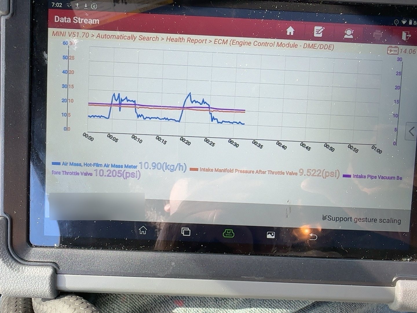 Scan tool live graph of air mass flow and intake manifold pressure while the engine is revved in the bay, with a pressure reading of roughly 16 psi shown. Vehicle identification in the footer is blurred.
