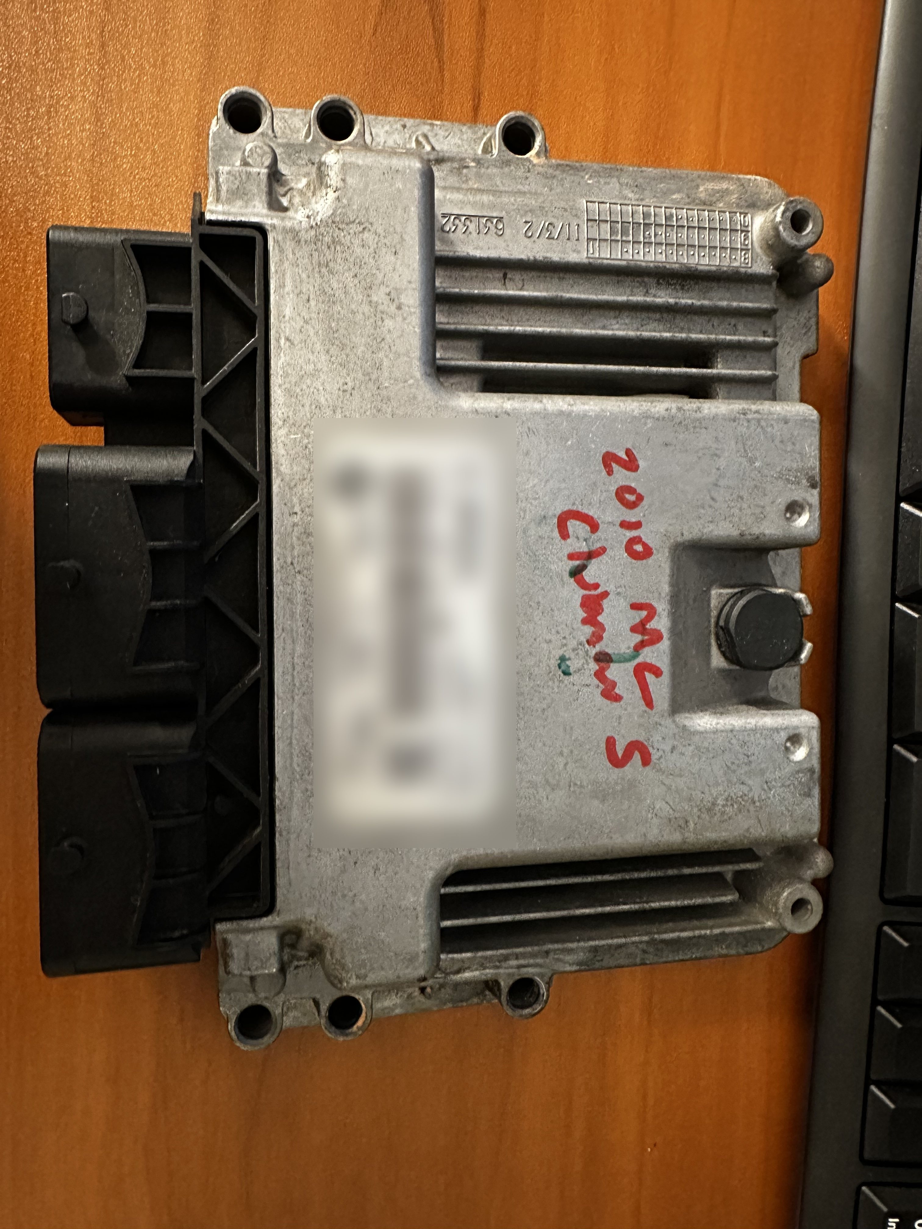 Second-generation MINI DME viewed from the identification side with three electrical connectors and the module label obscured